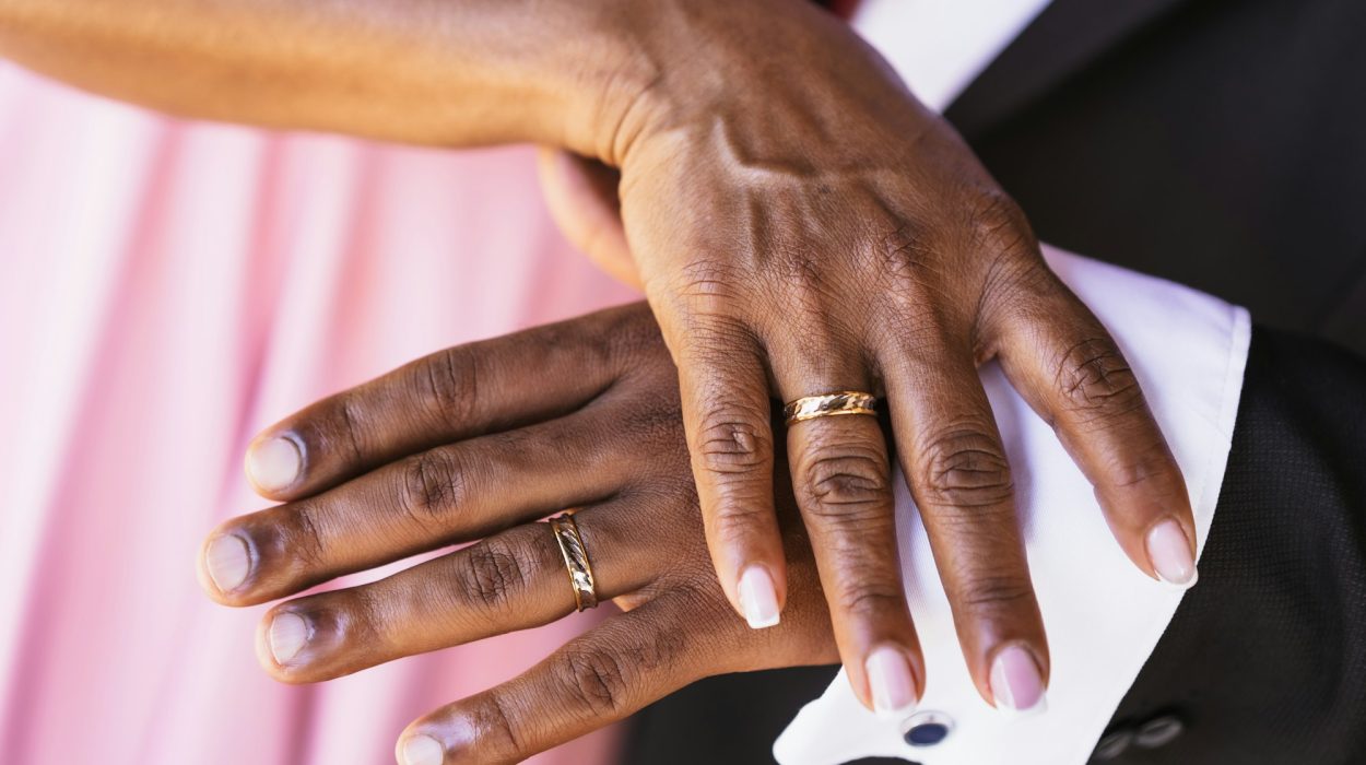Black ethnic wedding couple showing rings at a wedding, marriage ceremony