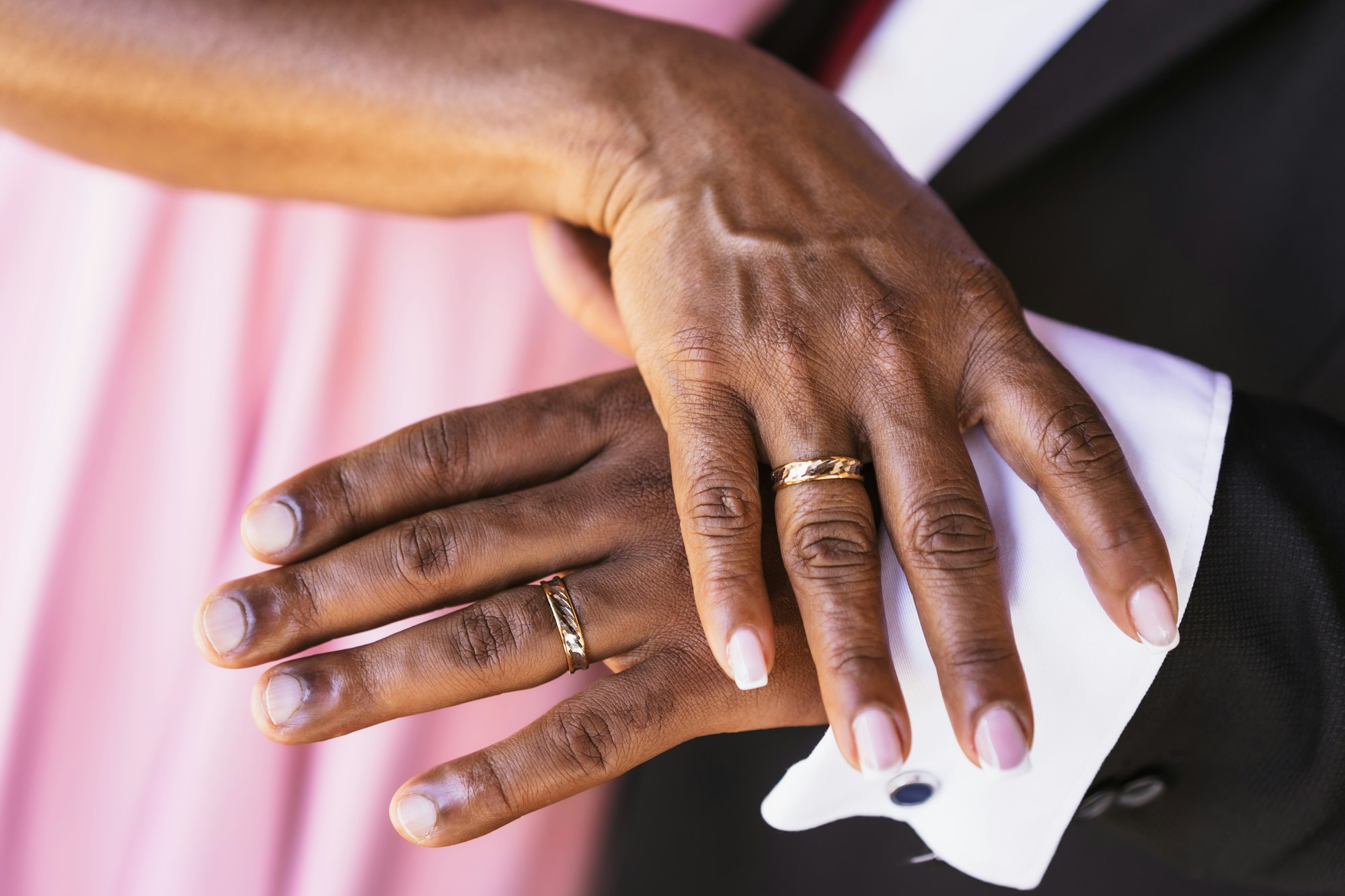 Black ethnic wedding couple showing rings at a wedding, marriage ceremony