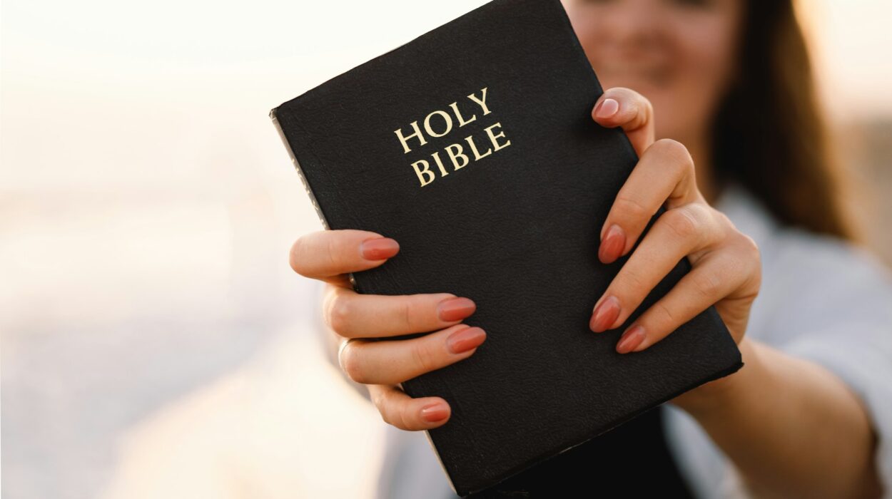 Christian woman holds bible in her hands. Reading the Holy Bible on the sea during beautiful sunset